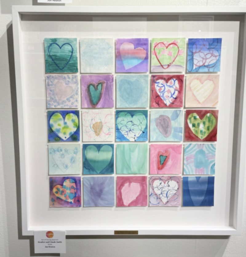 A framed collection of 25 small square artworks, each featuring a unique heart design with various colors and patterns. The hearts are arranged in a 5x5 grid, showcasing diverse artistic styles and creativity.