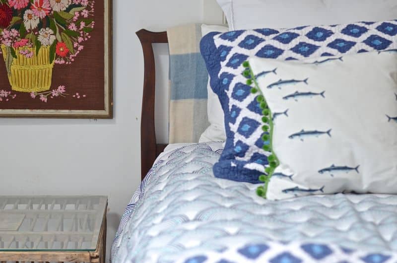 Guest bedroom with mixed patterns and textures. Gallery wall of embroidered art.