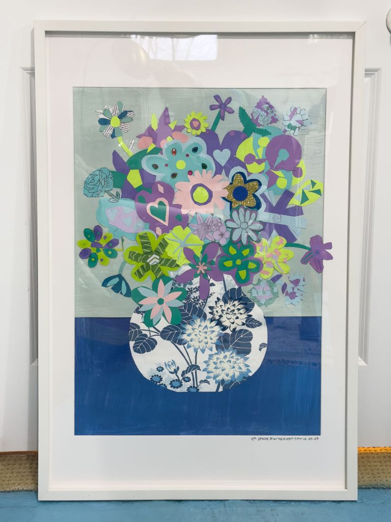 A framed artwork featuring a decorative vase filled with an array of colorful flowers, including blue, purple, and green hues. Some flowers have heart-shaped petals, and the background consists of subtle blue and gray tones.