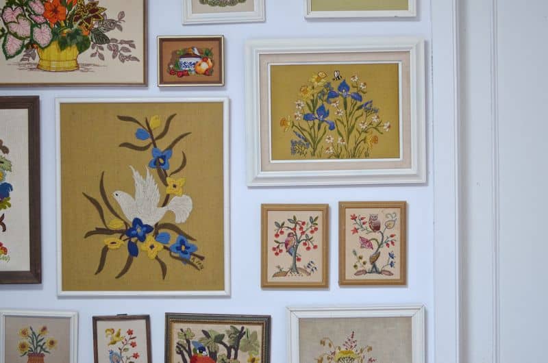 Guest bedroom with mixed patterns and textures. Gallery wall of embroidered art.