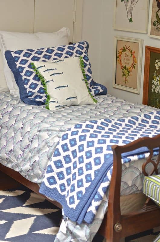 Guest bedroom with mixed patterns and textures. Gallery wall of embroidered art.