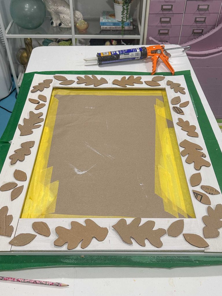 gluing cardboard shapes onto mirror