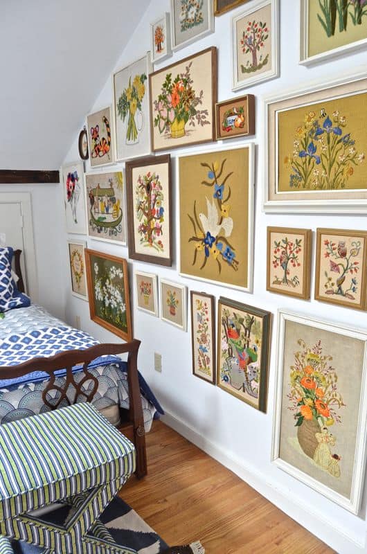 Guest bedroom with mixed patterns and textures. Gallery wall of embroidered art.