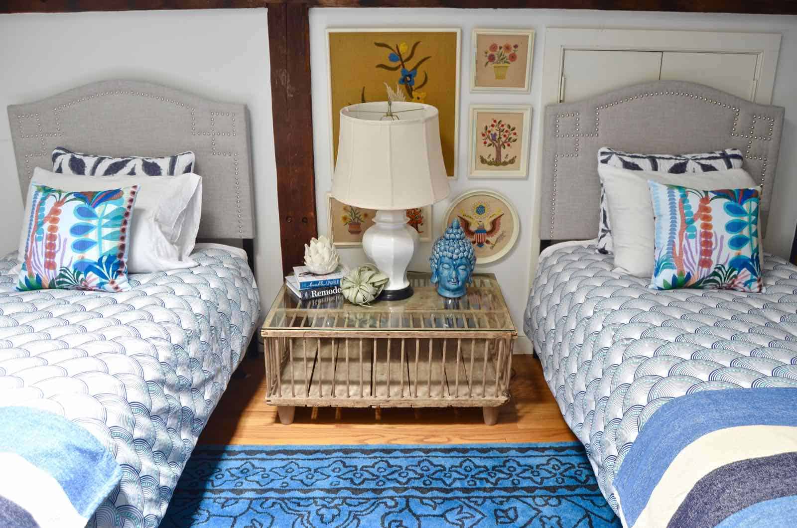 Updated guest room with new upholstered headboards and a repainted rich vintage gallery wall.