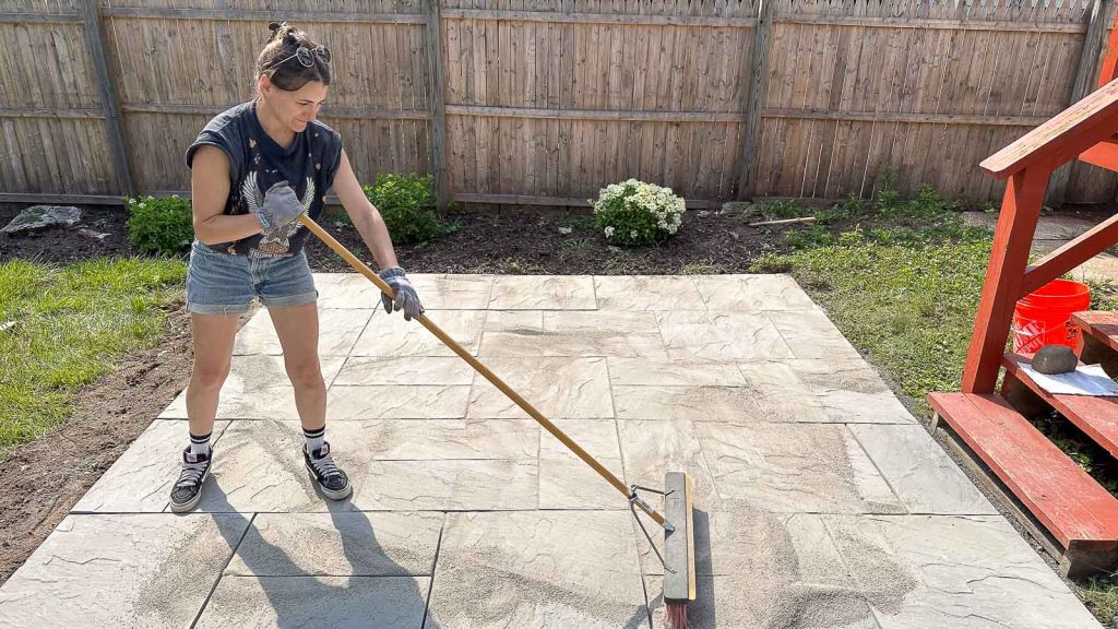 spreading polymeric sand on the patio