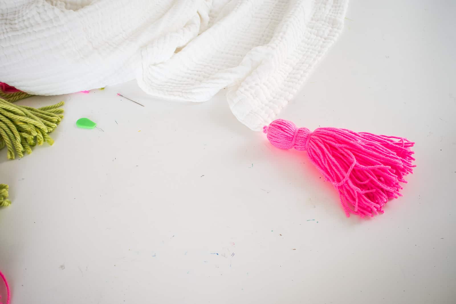 adding tassels to the muslin blanket