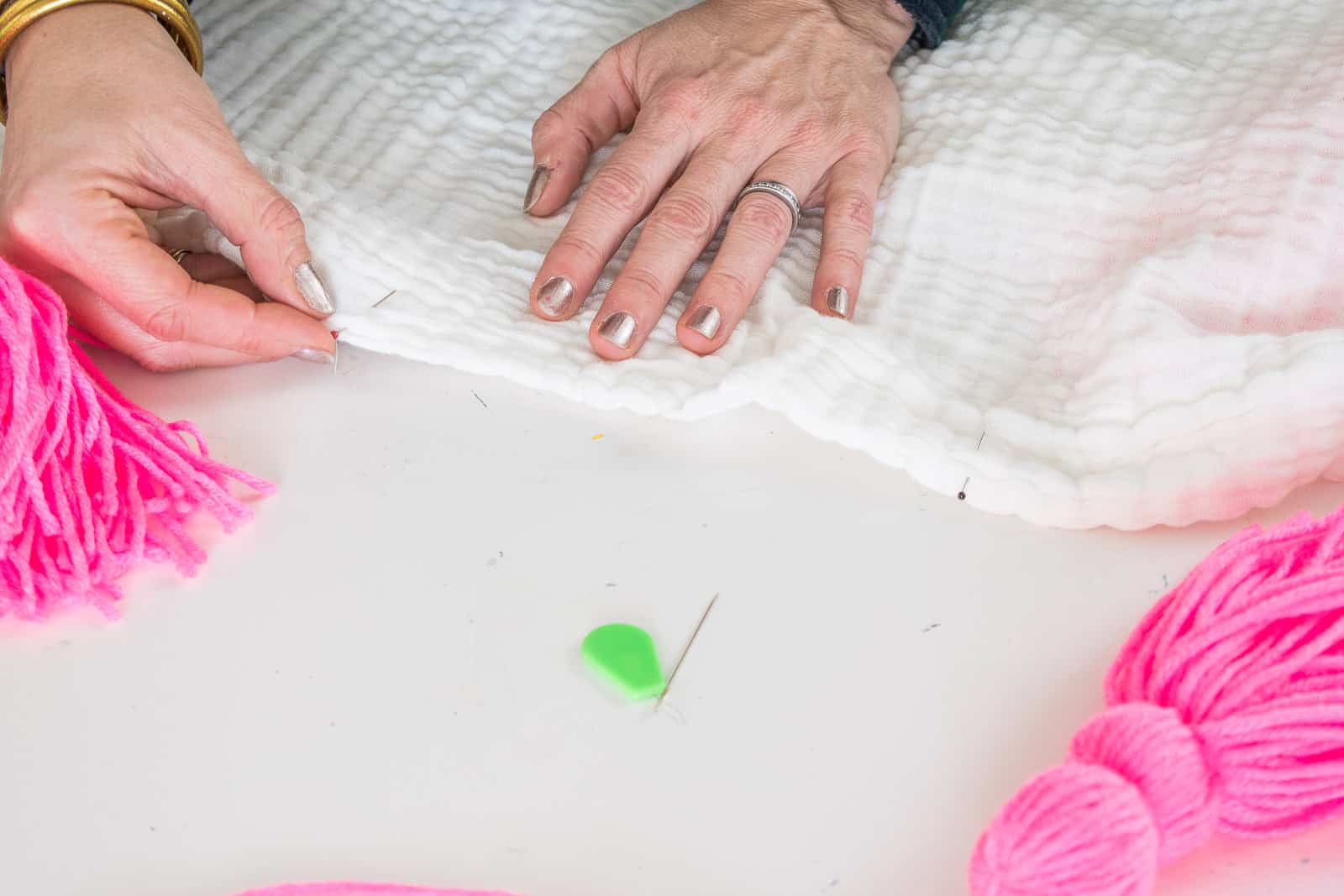 adding tassels to the muslin blanket