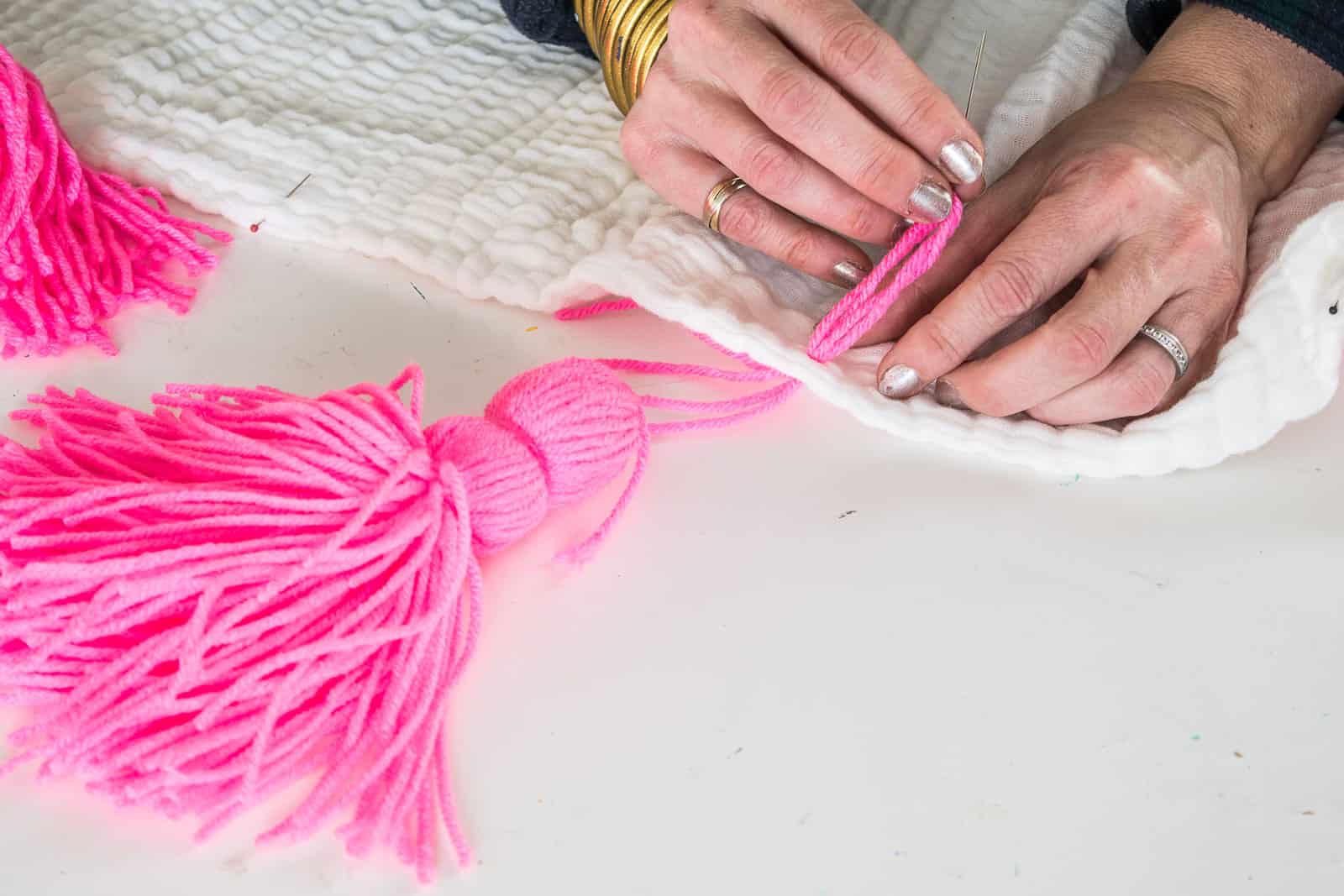 adding tassels to the muslin blanket