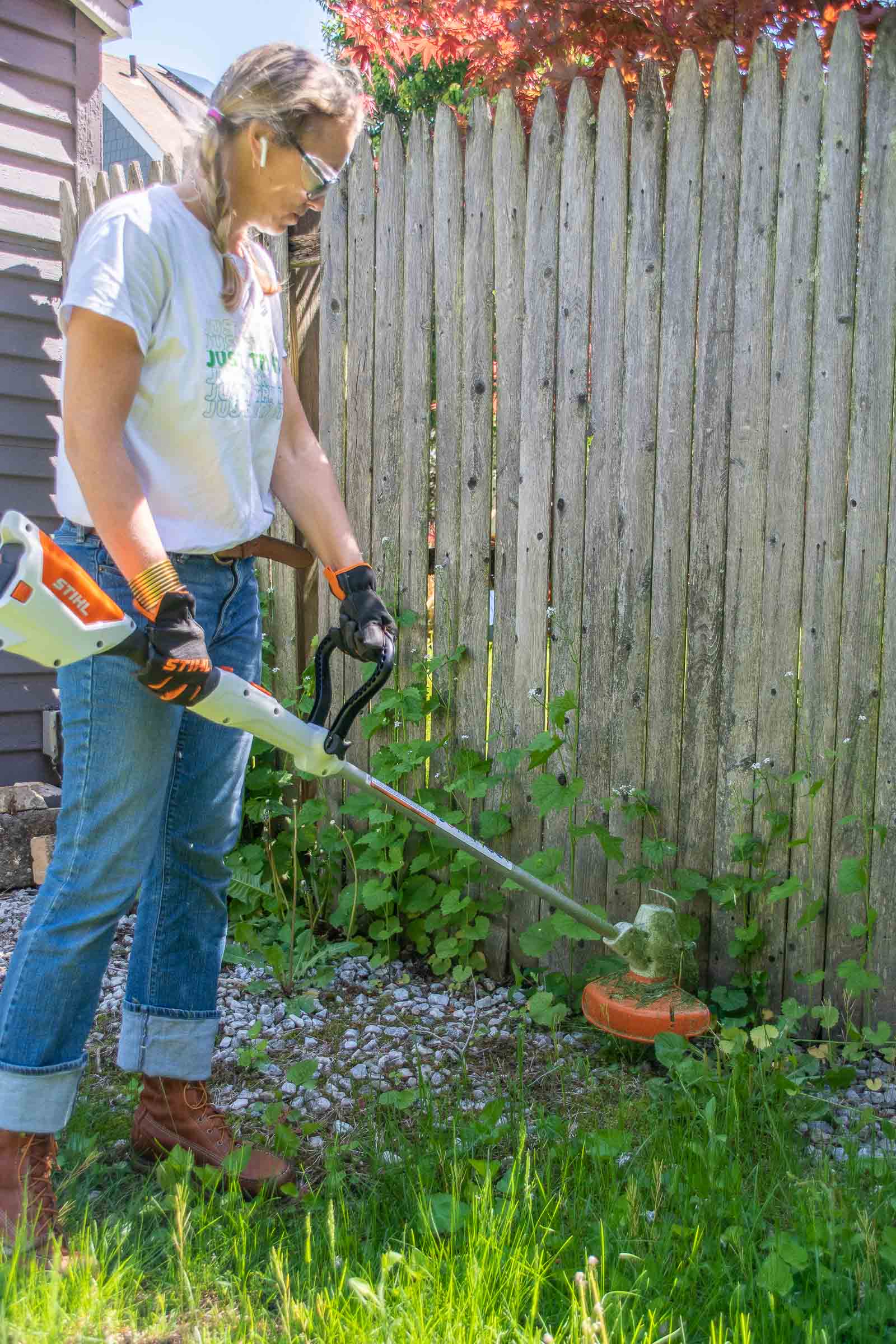 trimming weeds along the fence