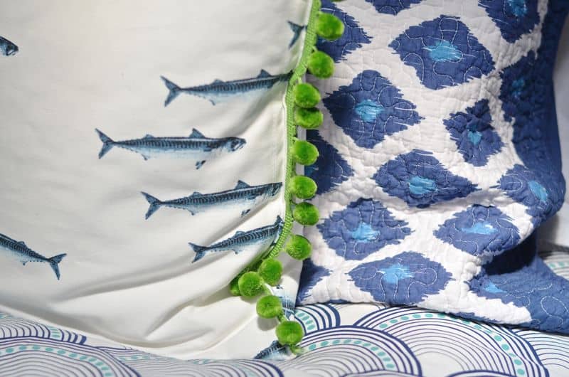 Guest bedroom with mixed patterns and textures. Gallery wall of embroidered art.