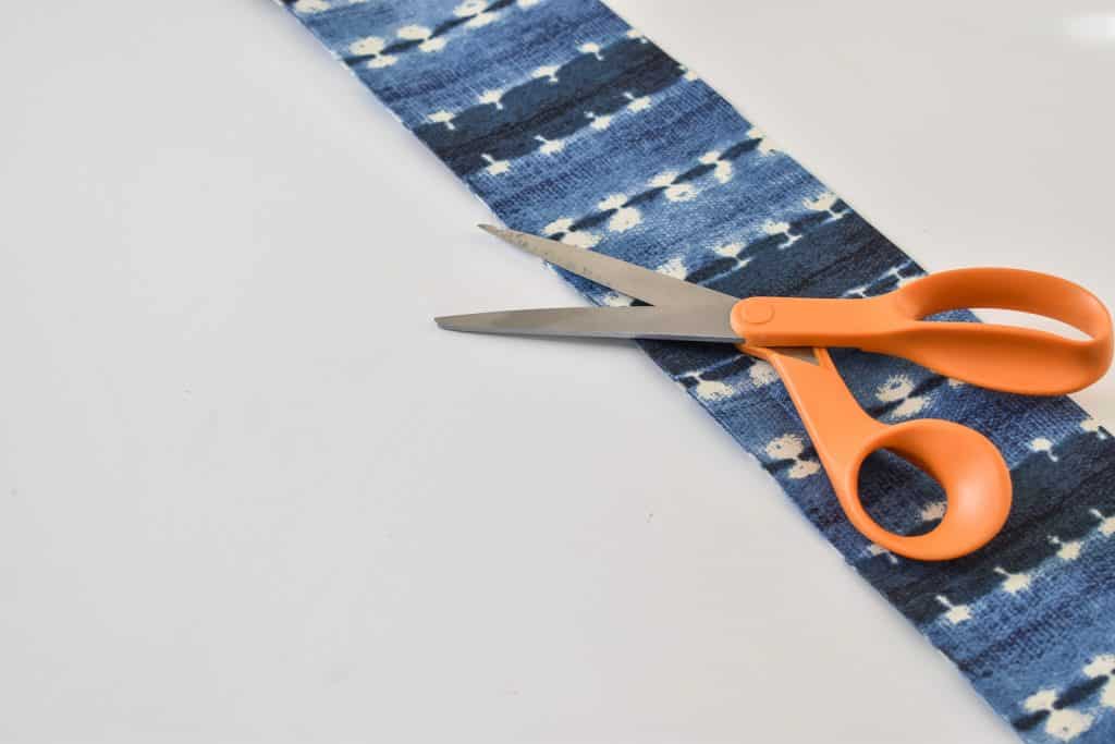 use a combination of hot glue and mod podge to adhere fabric to planter