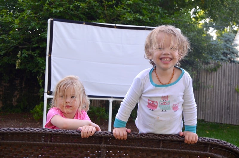 DIY backyard movie screen using PVC pipes and a clearance sheet.