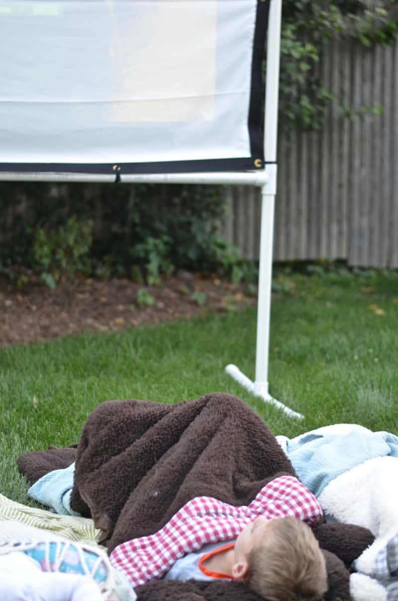 DIY backyard movie screen using PVC pipes and a clearance sheet.