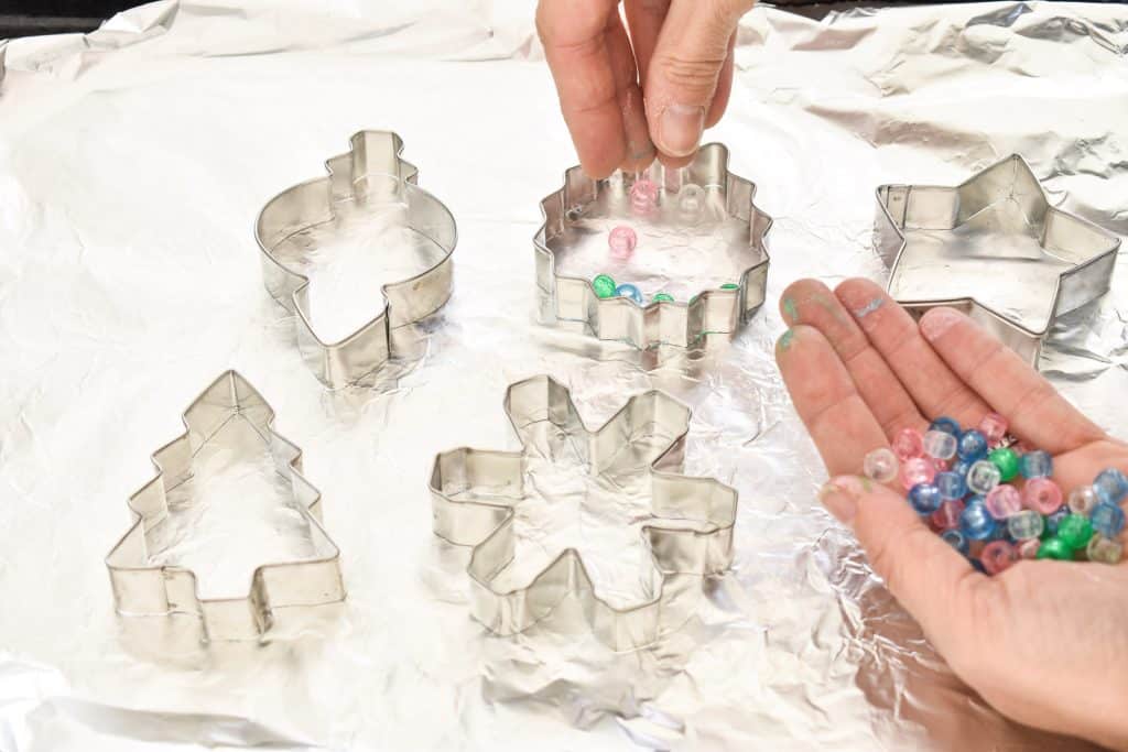 place pony beads into cookie cutters