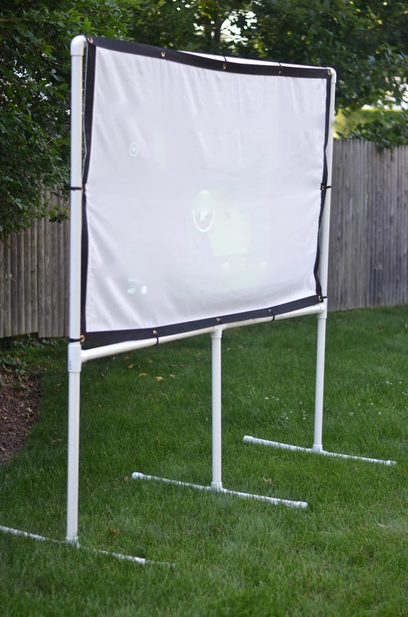 DIY backyard movie screen using PVC pipes and a clearance sheet.