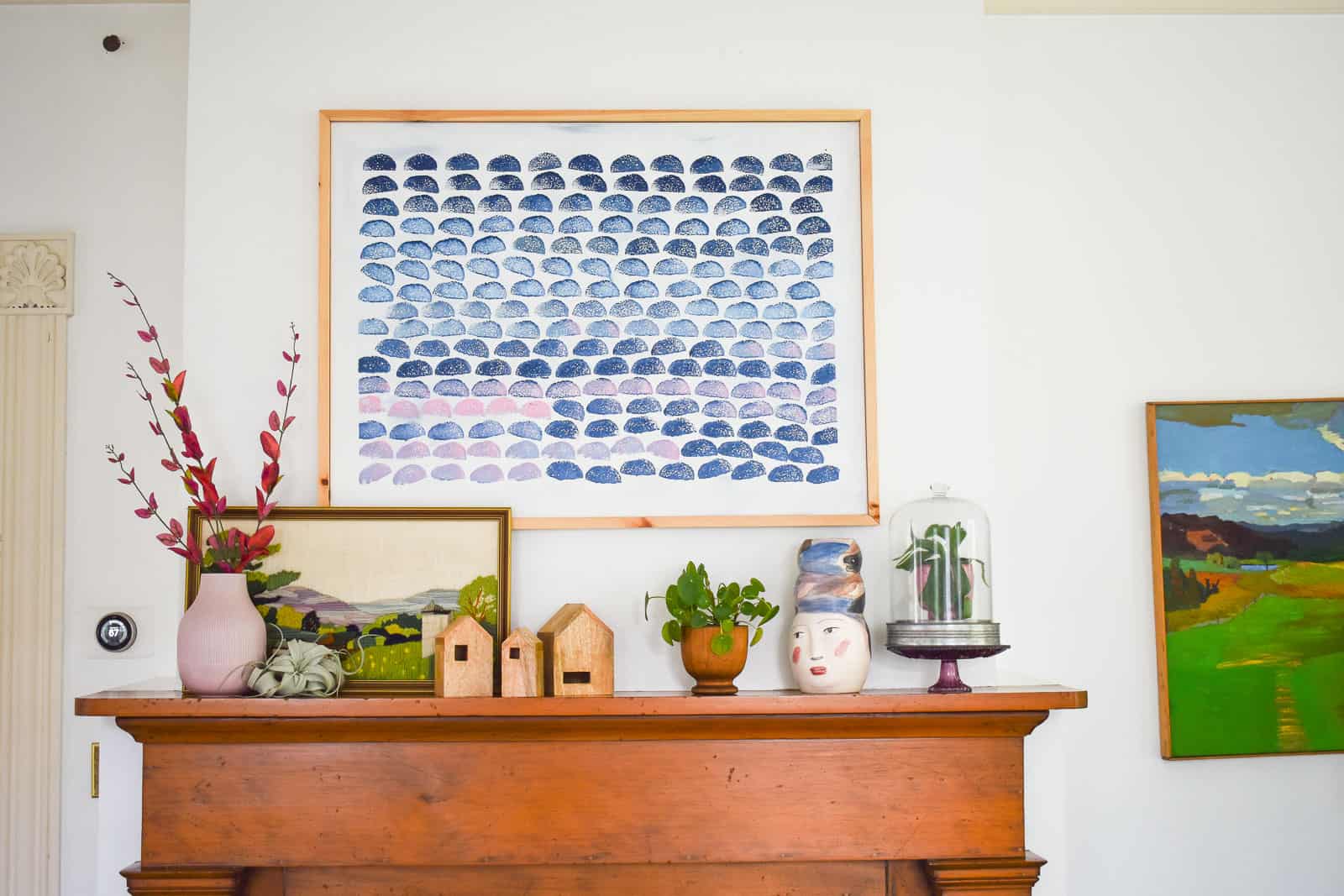 playing around with items on mantel under painting